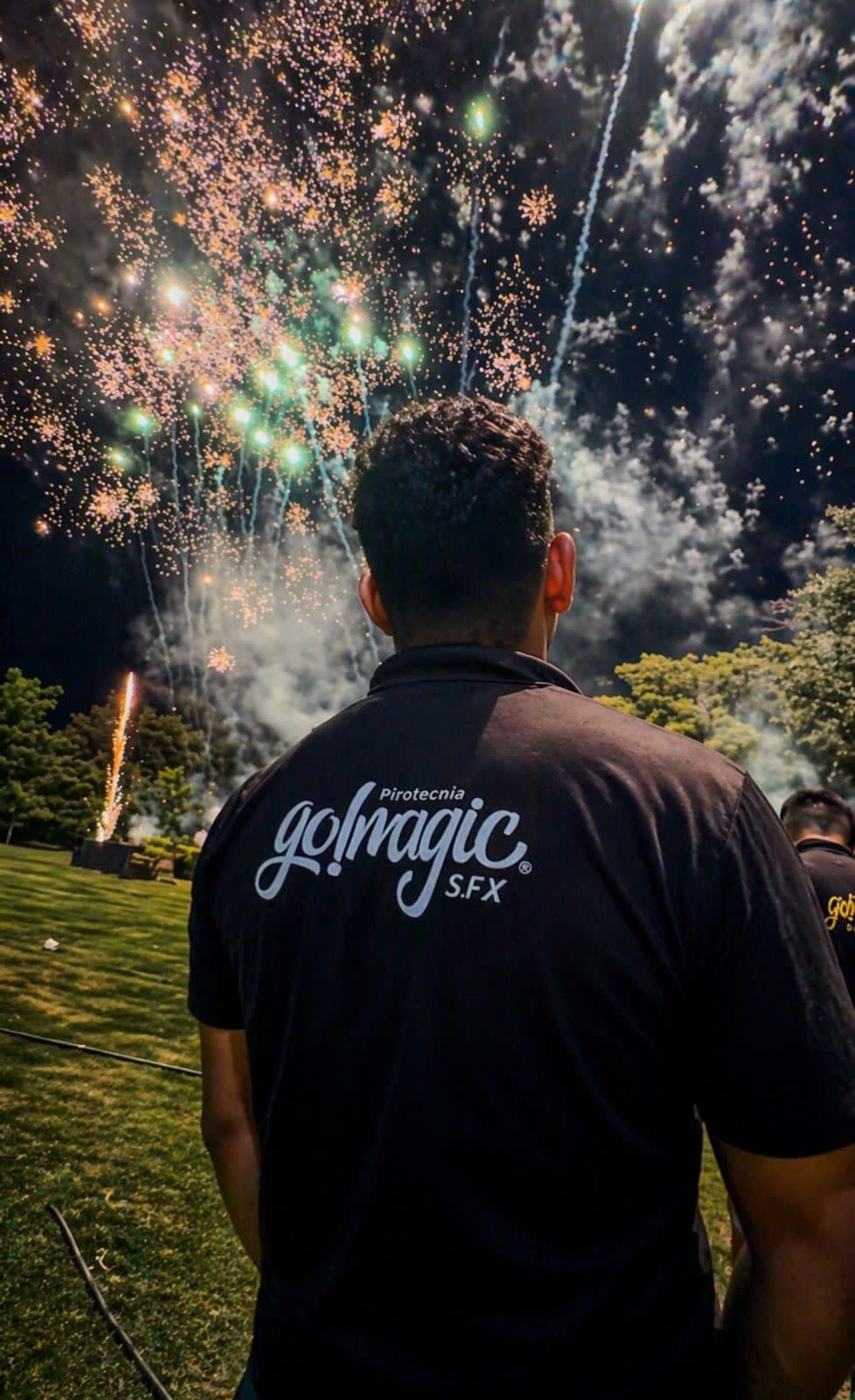 Técnico de Go!magic SFX de espaldas, con la camiseta de la empresa, frente a un show de fuegos artificiales.